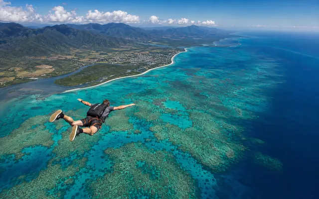 Skydiving over the coastline near Cairns and the reef